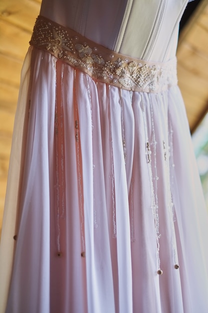 Wedding dress on a hook on a wooden covering