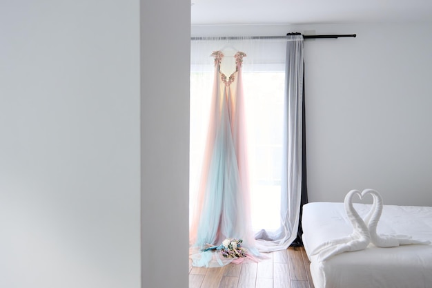 Свадебное платье и завеса на кровати в спальне