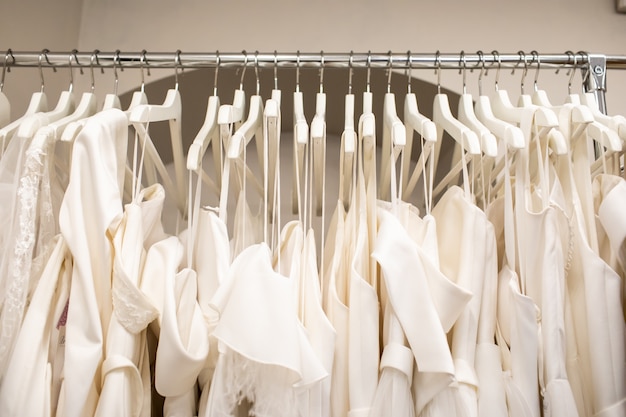 Wedding dresses hanging on a hanger. Fashion look. Interior of bridal salon.