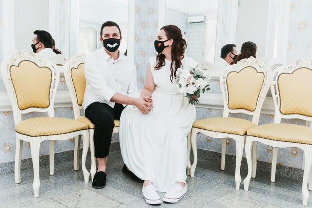 Photo wedding during the coronavirus epidemic. bride and groom in protective medical masks. marrieds and covid-19 pandemic.