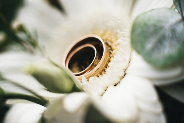 Wedding engagement rings and flowers wedding bouquet, selective focus, macro