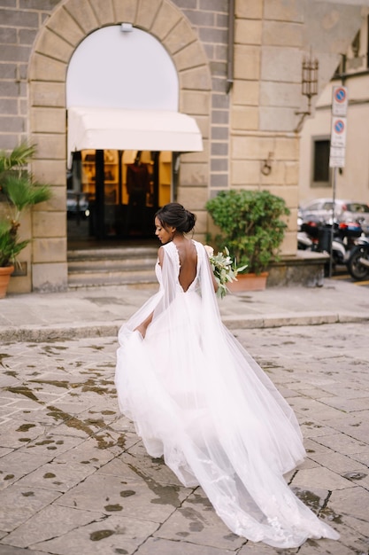 긴 베일과 부케가 있는 흰색 드레스를 입은 이탈리아 피렌체의 아프리카계 미국인 신부의 결혼식