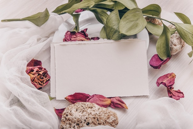 Foto mockup di carta di invito di fiori di nozze foglie tropicali e sfondo di pietra foto d'archivio in stile