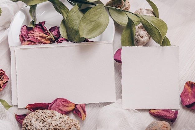 Foto mockup di carta di invito di fiori di nozze foglie tropicali e sfondo di pietra foto d'archivio in stile