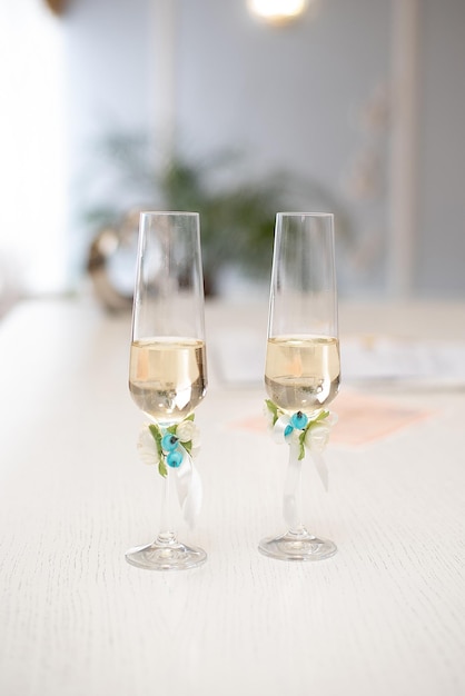 Wedding glasses with champagne wine on the table decorated with flowers