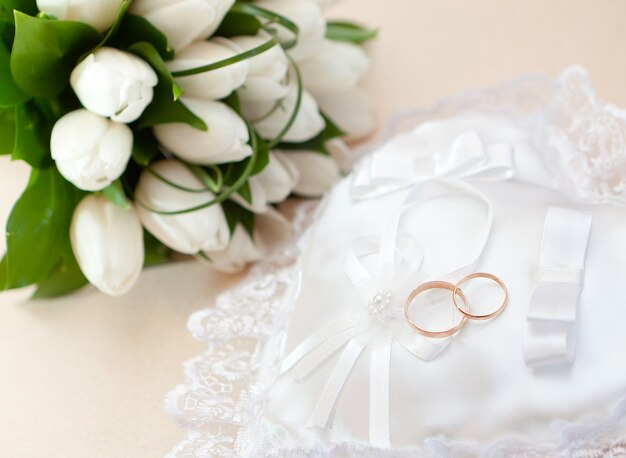 白い枕の上の結婚式の金の指輪