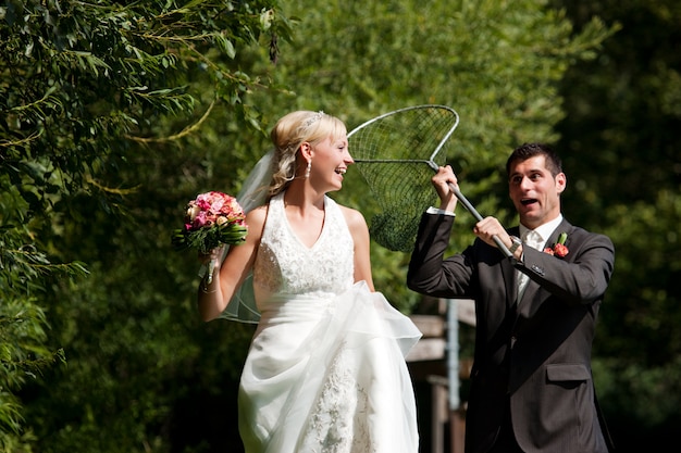 Photo wedding, groom catching his bride with dip net