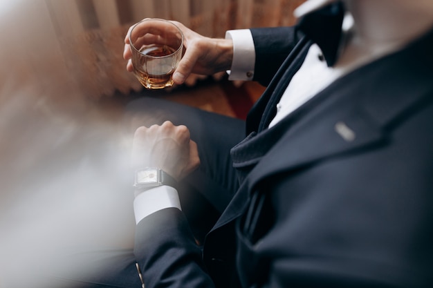 Wedding groom with glass of whiskey