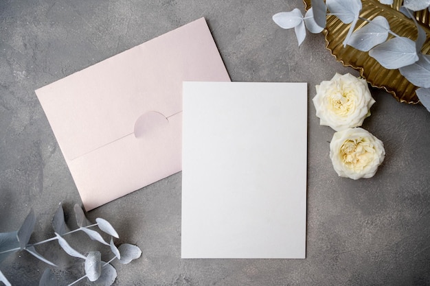 Foto mockup di carta di invito a nozze con eucalipto naturale e ramoscelli bianchi di gypsophila mockup di carta vuota su sfondo beige