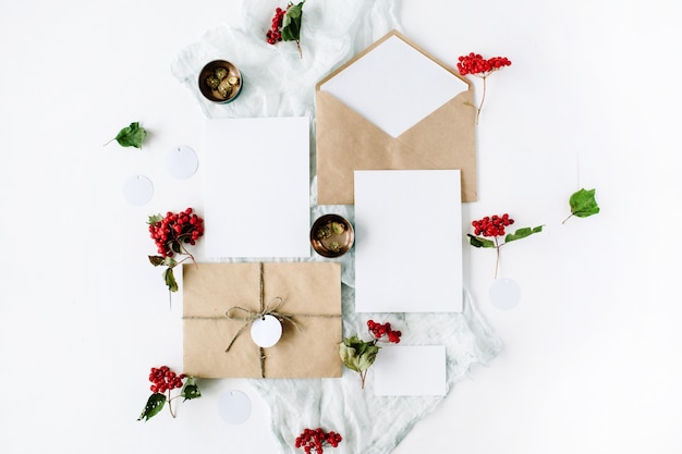 Photo wedding invitation cards, craft envelopes, pink and red roses and green leaves on white.