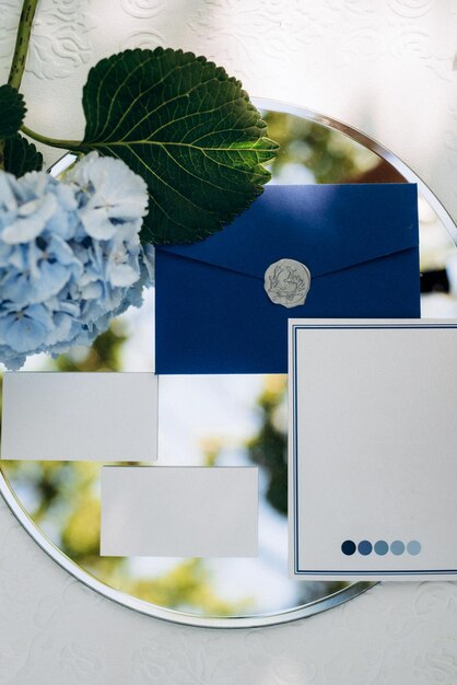 Photo wedding invitation in a gray envelope on a table with green sprigs