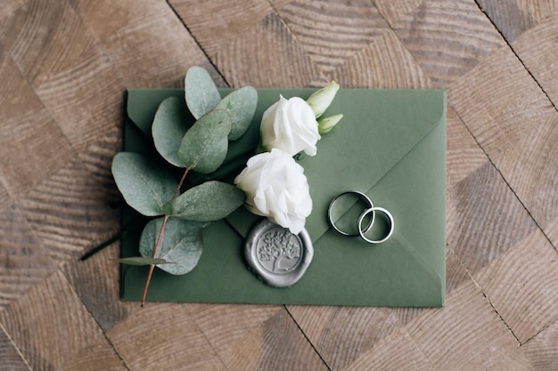 Wedding invitation for guests in green envelope on wooden background