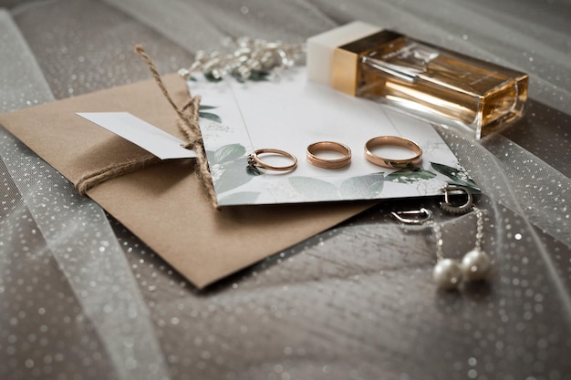 Photo wedding jewelry perfumes and envelopes with invitations on the table