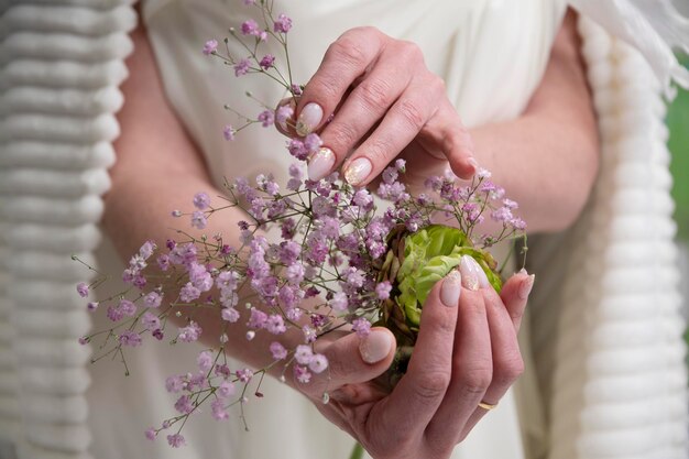 写真 結婚式のマニキュア花束を握っているウェディングドレスを着た女の子