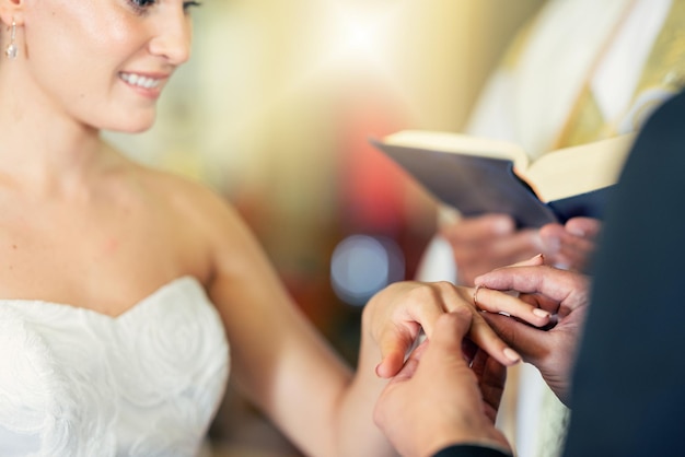 Foto matrimonio matrimonio e mettere l'anello al dito della sposa per celebrare l'amore romanticismo e l'impegno giovane coppia che si sposa in chiesa con lo sposo che dà gioielli alla moglie durante la cerimonia nuziale