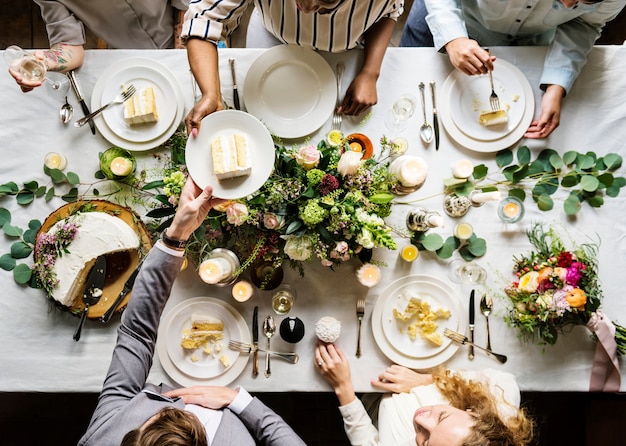 Wedding party sharing a cake at a table