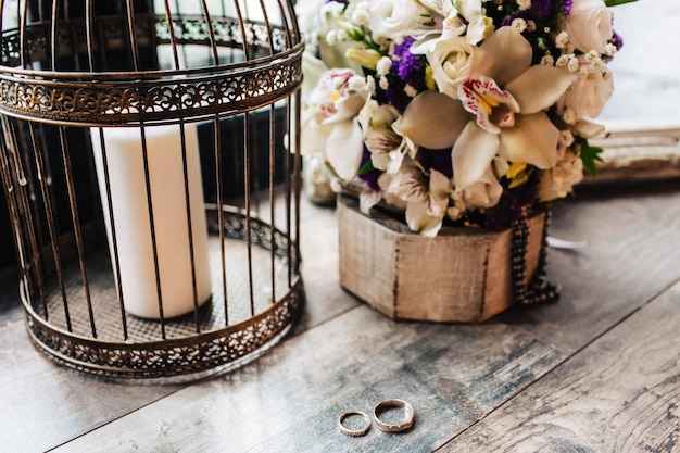 結婚式の写真木製のテーブルの上の結婚指輪花嫁の花束