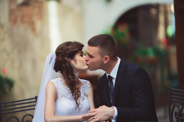 Wedding photography. bride and groom sitting in a cafe, embracing and smiling.