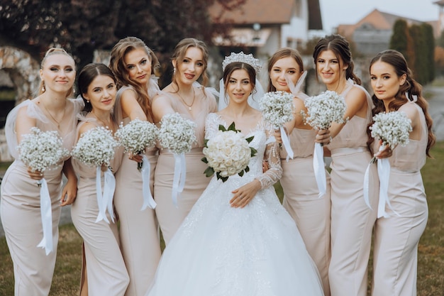 Photo wedding photography a brunette bride in a white dress with a bouquet and her brunette girlfriends