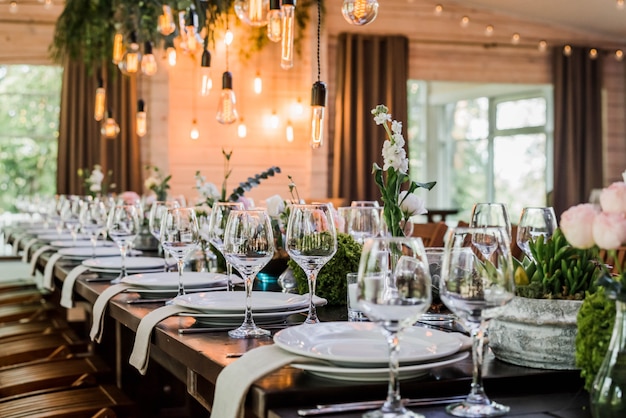 Wedding reception table with Edison bulbs and decor of greenery.