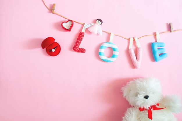 결혼 반지, 공예 및 손 분홍색 배경에 사랑 알파벳을 만든