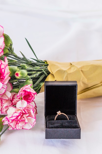 Wedding ring with flowers bouquet on table