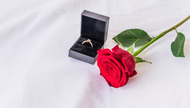 Wedding ring with rose on white table