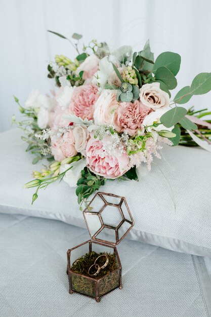 Photo wedding rings are in a wooden box with flower petals