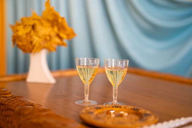 Wedding rings on a background of glasses of champagne