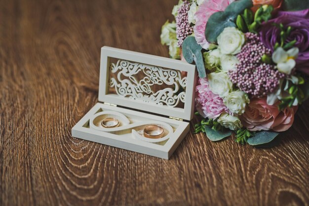 Wedding rings in a beautiful carved box and a colorful bouquet 2231