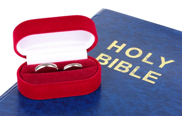 Wedding rings on bible isolated on white