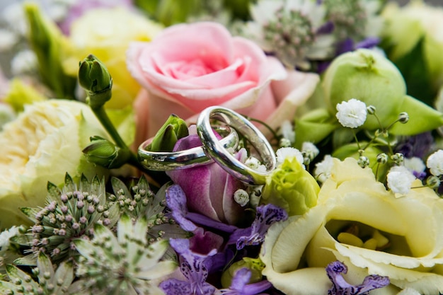 Foto anelli di nozze al centro del bouquet di nozze