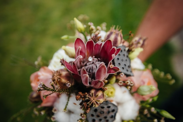 Wedding rings close-up on a beautiful wedding bouquet during sunset. Wedding accessories