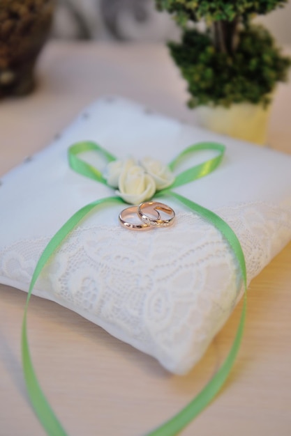 Wedding rings on a cushion with green bow