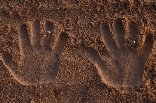 Foto fedi nuziali incastonate nella sabbia della spiaggia 2