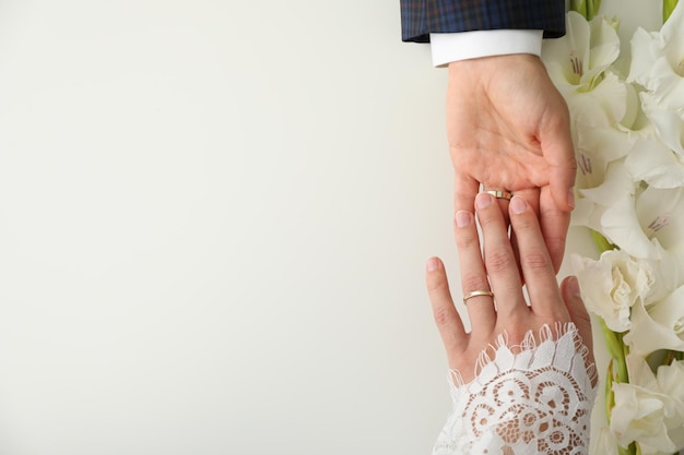 Photo wedding rings on female and male hand on white background space for text