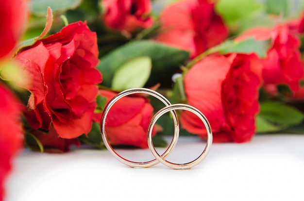 Wedding rings and flowers isolated on white background