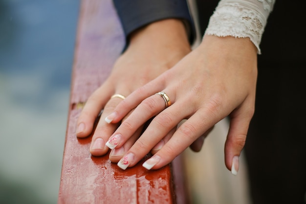 Wedding rings on the hands of the bride and groom close-up