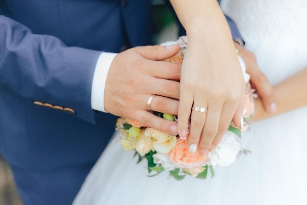 wedding rings on the hands of the bride and groom close up