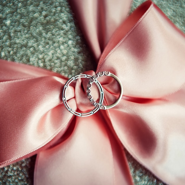 Wedding rings. jewelery in white and yellow gold. Wedding ring on satin ribbon. white lace.