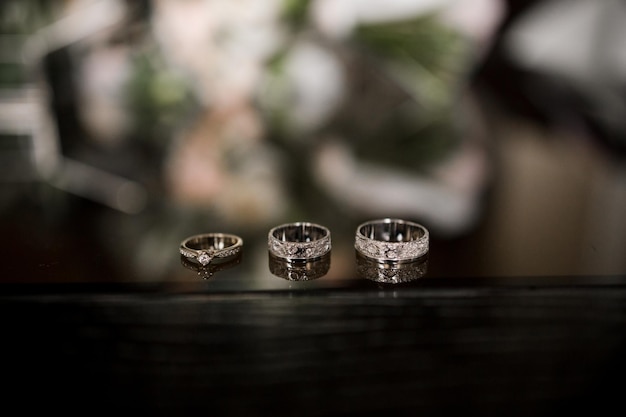 Wedding rings lie on a dark table