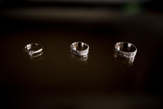 결혼 반지는 어두운 테이블에 놓여 있습니다.