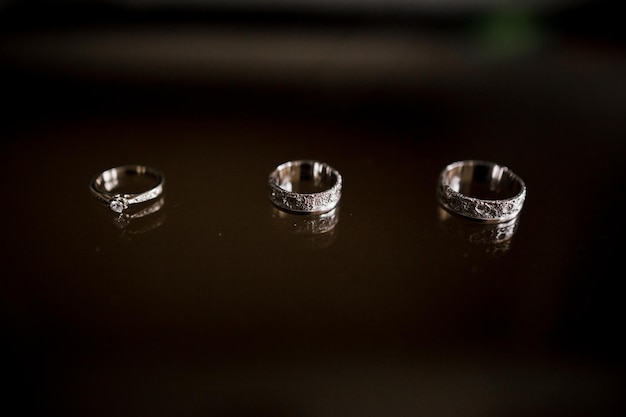 Wedding rings lie on a dark table