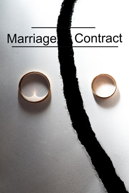 사진 찢어진 백서의 다른 반쪽에 있는 결혼 반지 깨진 단어 결혼 계약