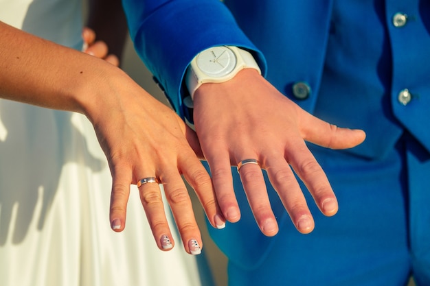 사진 신부와 신랑의 손가락에 결혼 반지. 해변에서 결혼식의 개념입니다.