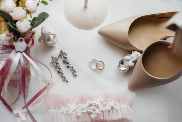 Primo piano di fedi nuziali e altri accessori durante la riunione della sposa. nozze.