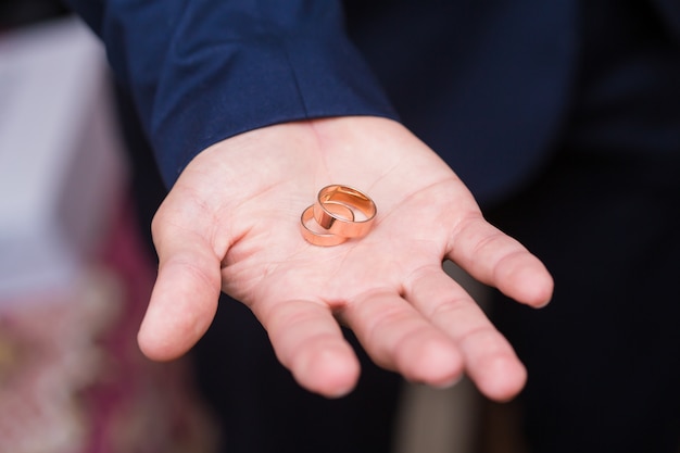 Wedding rings on the palm of groom, marriage proposal