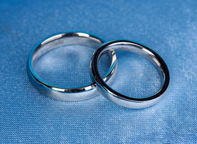 Wedding rings on satin pillow closeup