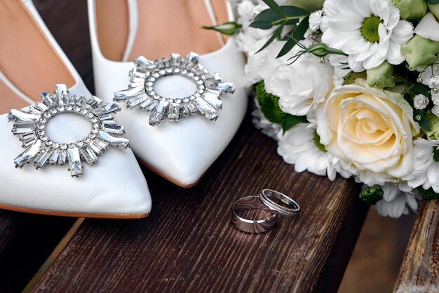 Photo wedding rings and shoes on background