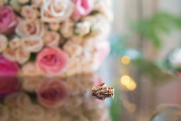 Wedding rings on the table with a bouquet